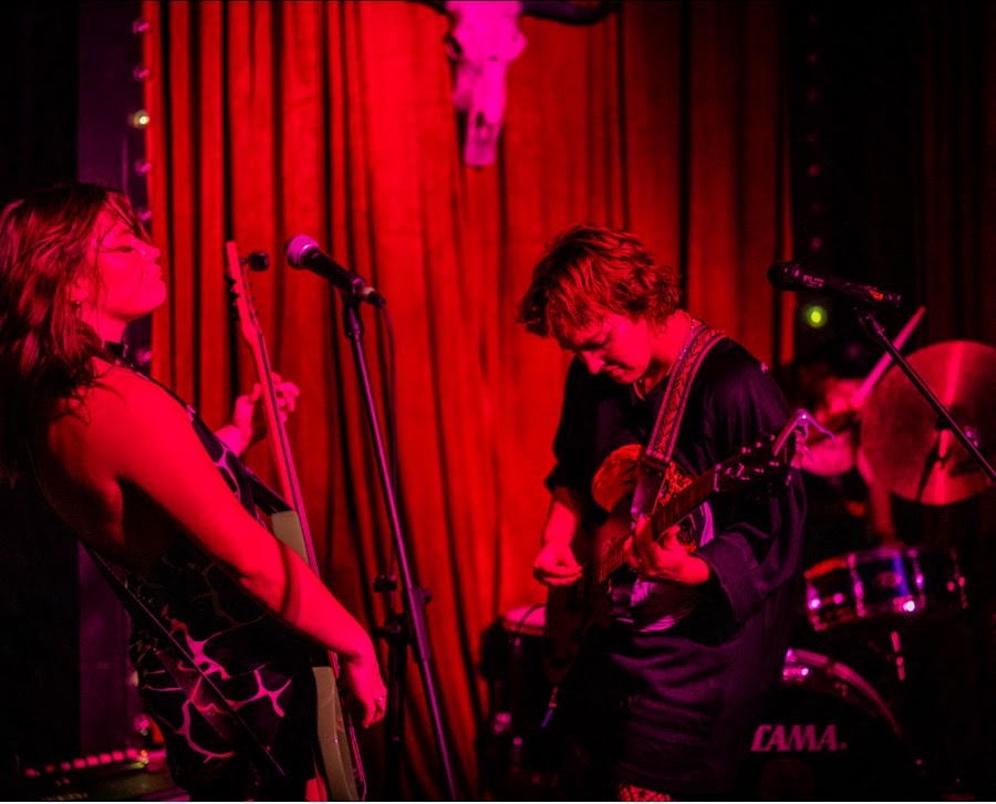 Band performing live on stage with red velvet curtains at Firehouse Lounge